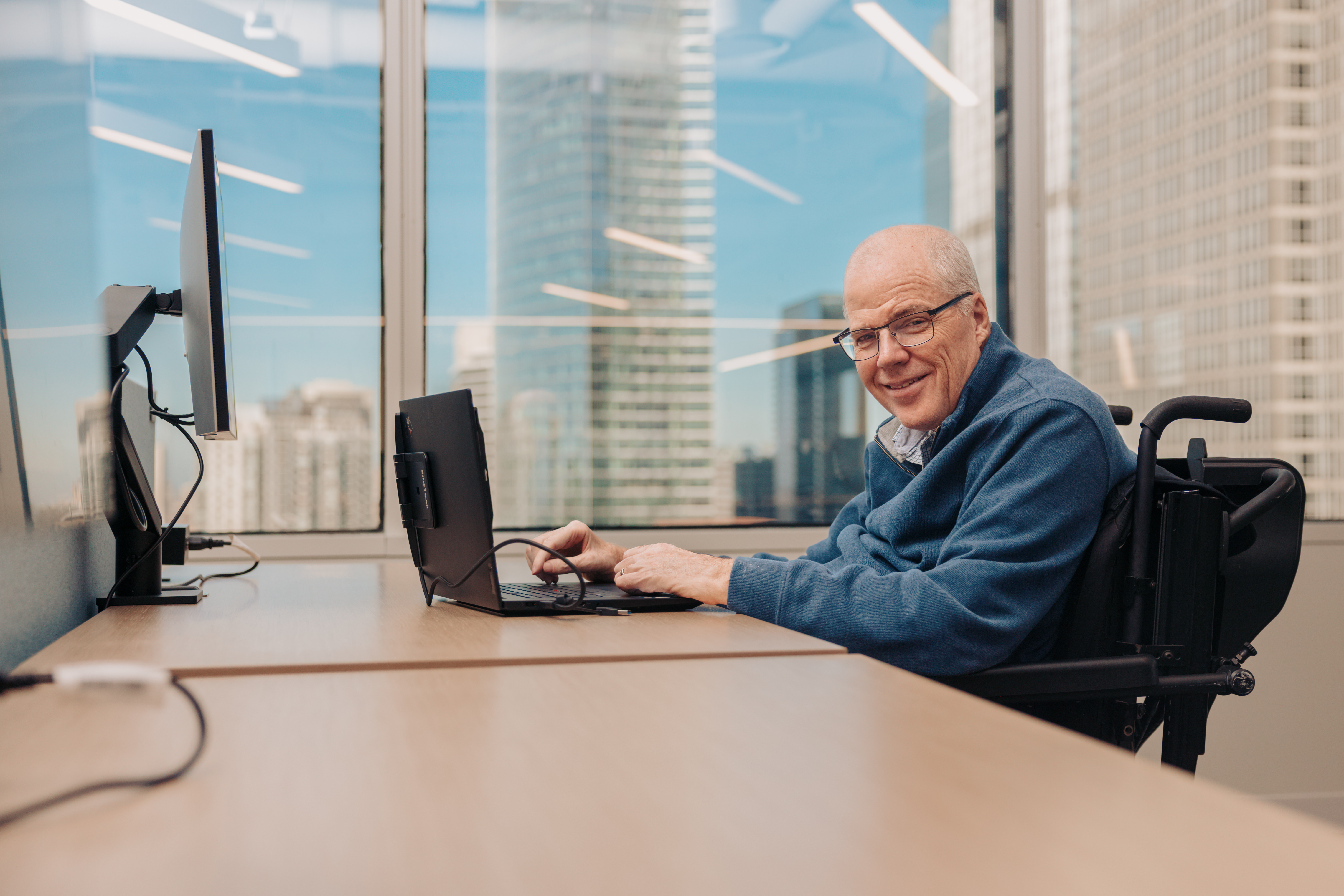 Mike working productively in an office, representing inclusive employment opportunities.